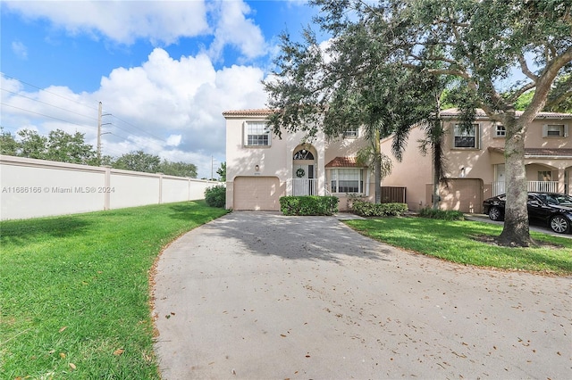 mediterranean / spanish-style home with a garage and a front yard