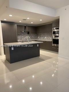 kitchen featuring light tile patterned flooring, tasteful backsplash, stainless steel double oven, and sink