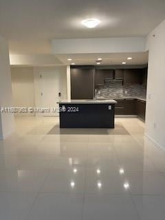 kitchen featuring dark brown cabinetry and light tile patterned floors