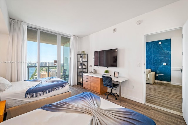 bedroom featuring built in desk, access to outside, and hardwood / wood-style floors