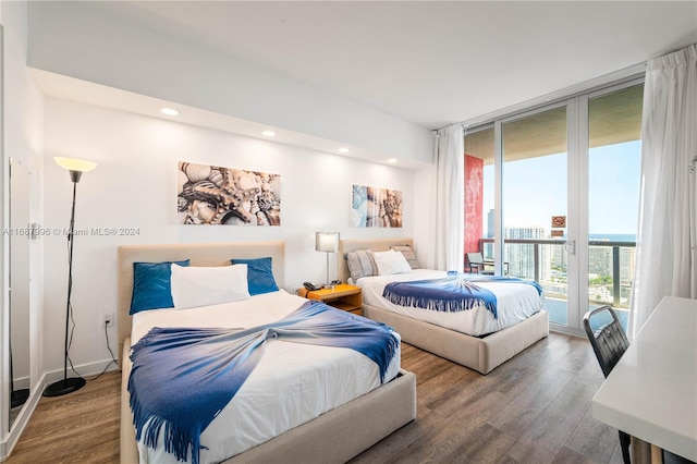 bedroom featuring access to outside, floor to ceiling windows, and hardwood / wood-style floors