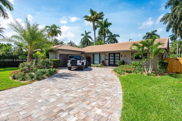 single story home featuring a front yard, french doors, and a garage