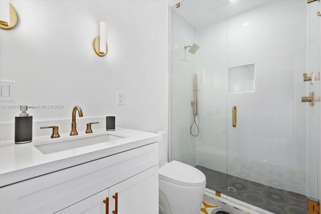 bathroom featuring vanity, toilet, and a shower with shower door