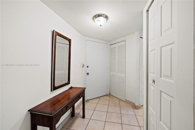 entryway with a textured ceiling and light tile patterned floors