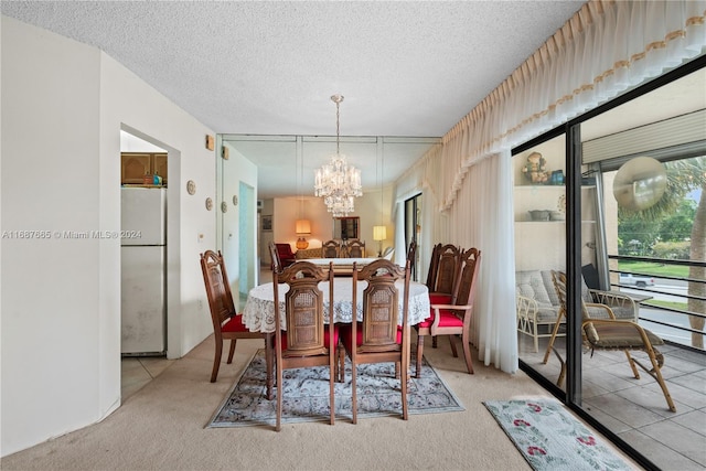 dining room featuring a textured ceiling, carpet flooring, and a notable chandelier