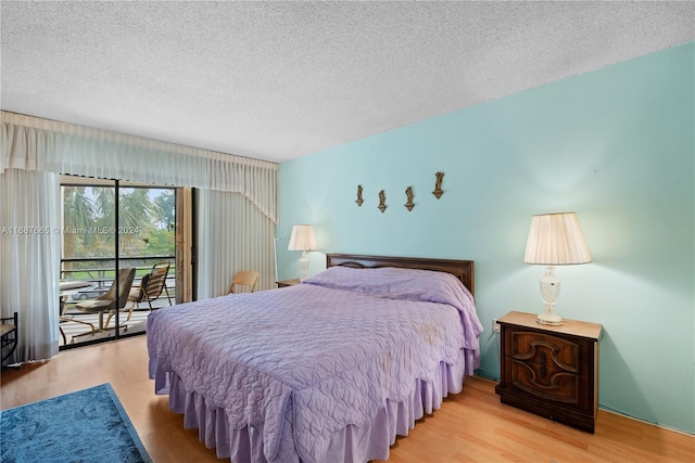 bedroom with a textured ceiling, light hardwood / wood-style floors, and access to exterior