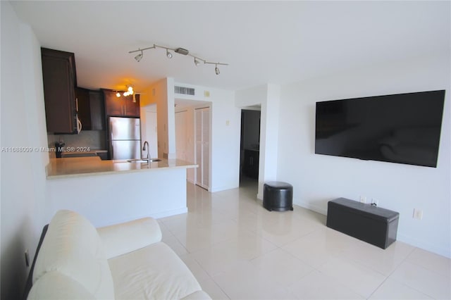 tiled living room featuring rail lighting and sink