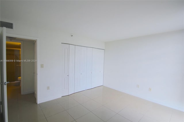 unfurnished bedroom featuring light tile patterned floors and a closet