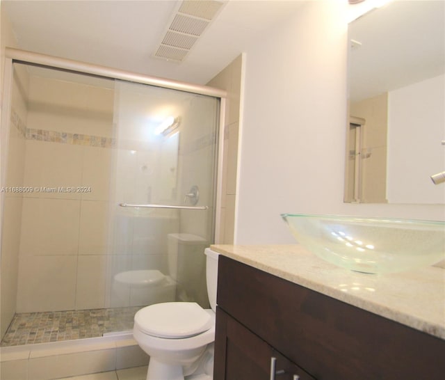 bathroom with walk in shower, vanity, tile patterned floors, and toilet