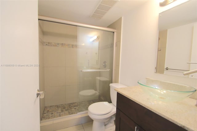 bathroom with tile patterned floors, vanity, toilet, and an enclosed shower