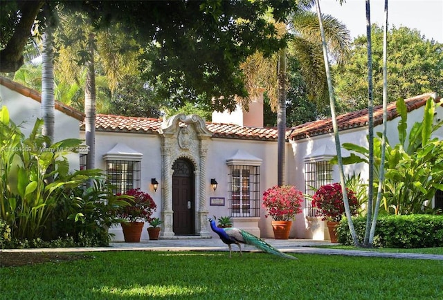 7065 Fisher Island Dr Unit 7065, Miami Beach, FL 33109 - mediterranean / spanish home featuring a tiled roof, stucco siding, and a front lawn