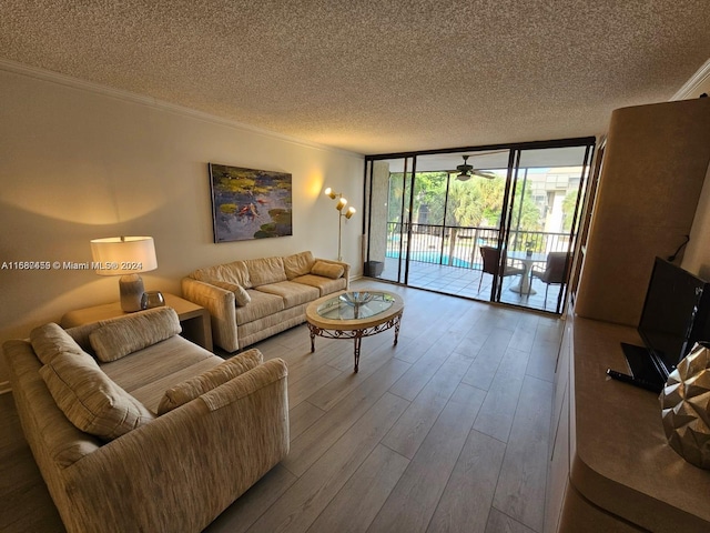 living room featuring expansive windows, a textured ceiling, hardwood / wood-style flooring, and crown molding