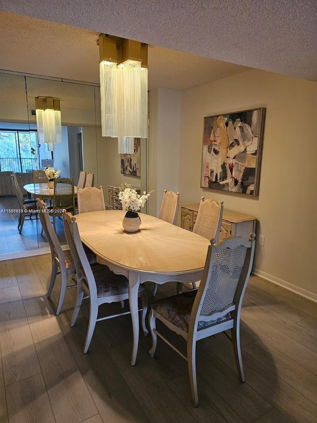 dining space featuring hardwood / wood-style flooring and a textured ceiling