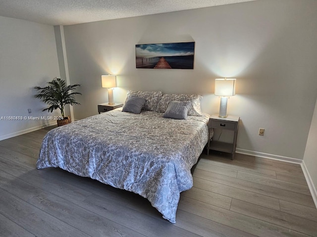 bedroom featuring wood-type flooring and a textured ceiling