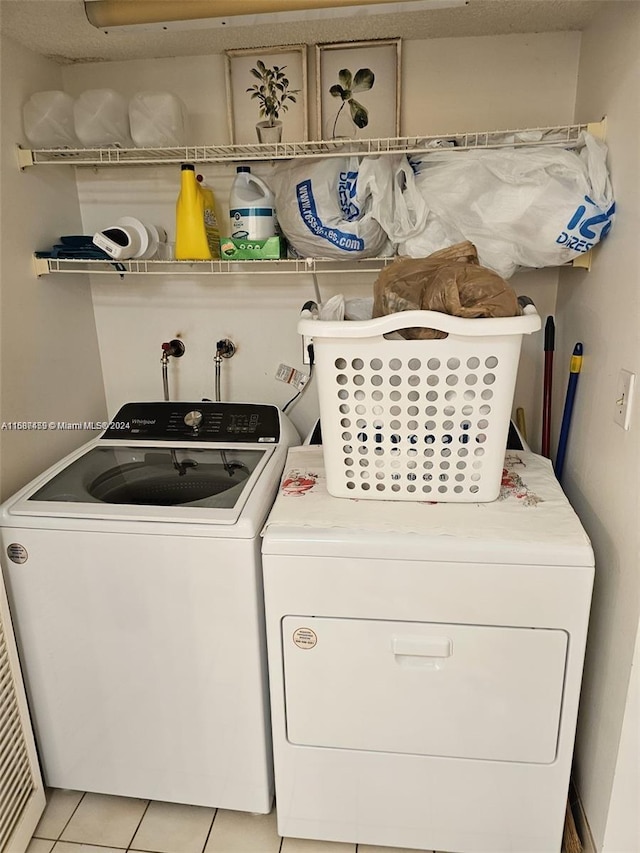 laundry room featuring washer and dryer and light tile patterned floors