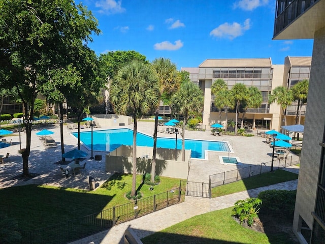 view of pool featuring a patio and a yard