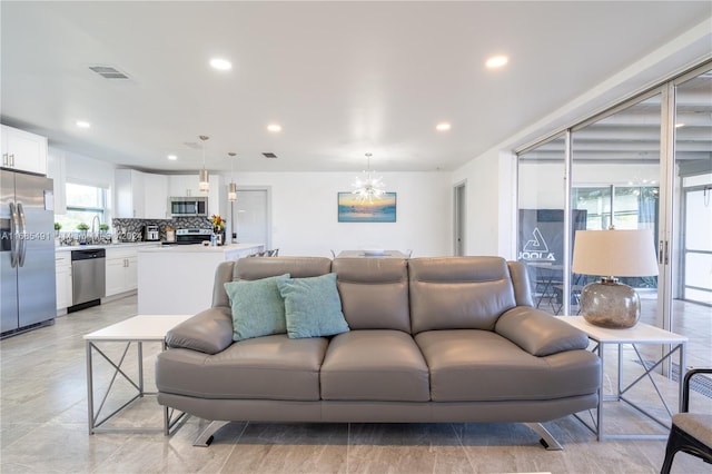 living room featuring sink and a notable chandelier