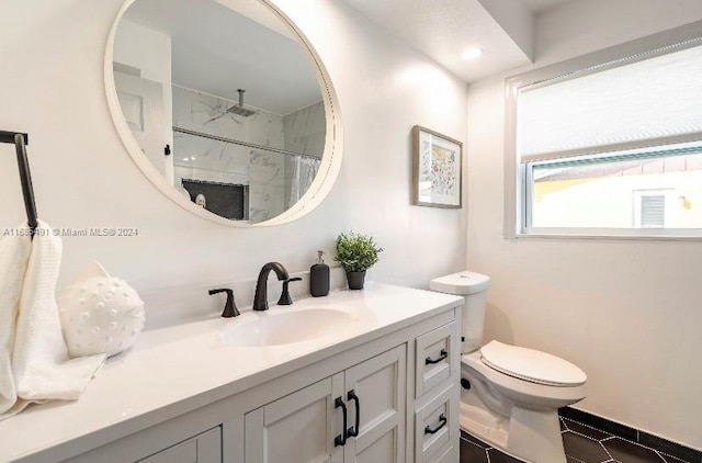 bathroom featuring toilet, vanity, tile patterned flooring, and a tile shower