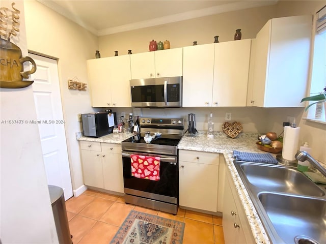 kitchen with white cabinetry, sink, light tile patterned flooring, and stainless steel appliances