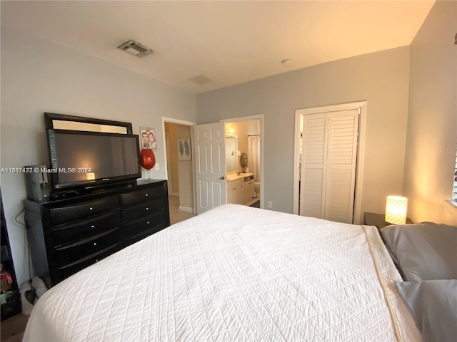 bedroom with ensuite bath and a closet