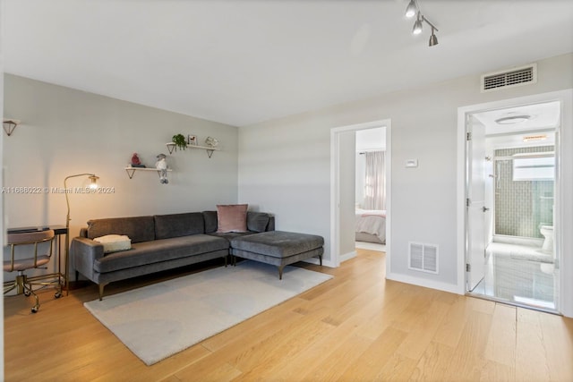 180 NE 12th Ave Unit 12E, Hallandale Beach, FL 33009 - living room with light wood finished floors, track lighting, and baseboards