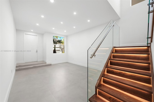 stairs with concrete flooring and a barn door