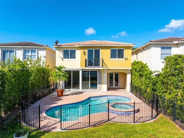 rear view of house featuring a fenced in pool and a patio area