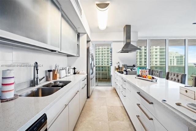 kitchen featuring white cabinetry, sink, range hood, stainless steel fridge, and dishwashing machine