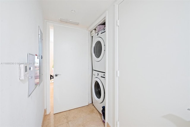 washroom with stacked washer and dryer and light tile patterned flooring