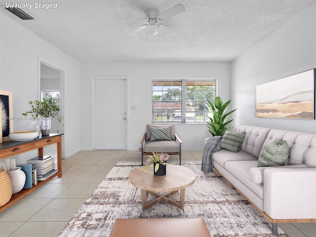 tiled living room featuring a textured ceiling and ceiling fan