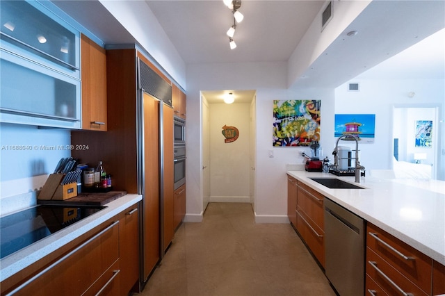 kitchen featuring dishwasher, track lighting, black electric stovetop, and sink