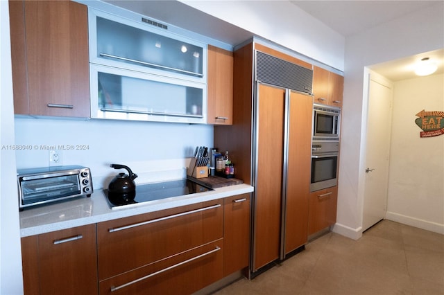 kitchen with light tile patterned flooring and built in appliances