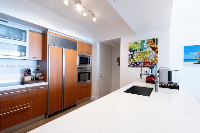 kitchen with built in appliances and sink