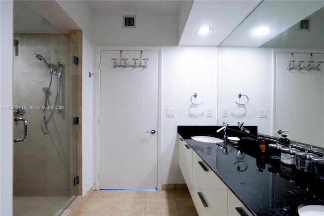 bathroom featuring walk in shower, vanity, and tile patterned floors