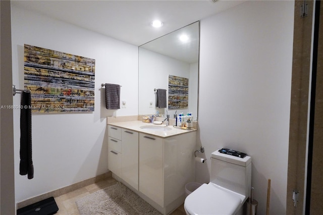 bathroom featuring tile patterned flooring, vanity, and toilet