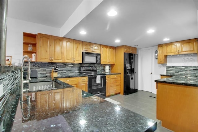 kitchen featuring light tile patterned flooring, dark stone countertops, black appliances, and decorative backsplash