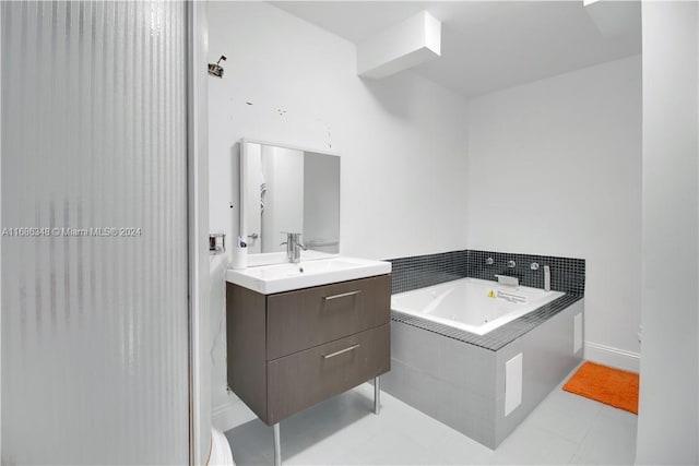 bathroom featuring tiled bath, tile patterned flooring, vanity, and toilet