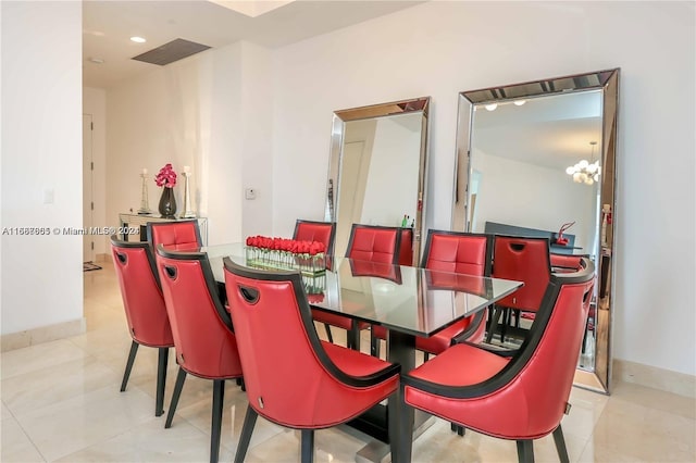 dining room with light tile patterned floors and an inviting chandelier