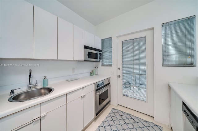 kitchen with white cabinets, stainless steel appliances, and sink