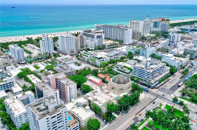 drone / aerial view featuring a beach view and a water view