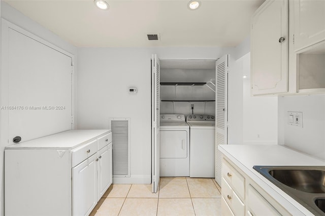 clothes washing area featuring light tile patterned flooring and washing machine and clothes dryer