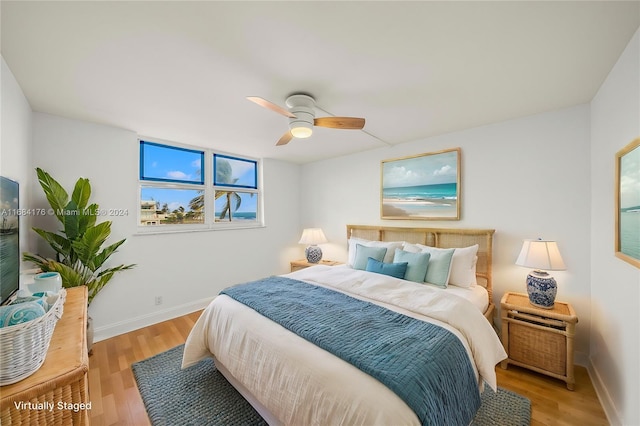 bedroom with ceiling fan, multiple windows, and light wood-type flooring