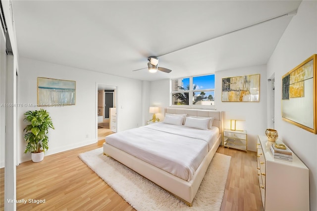 bedroom with connected bathroom, ceiling fan, and light hardwood / wood-style flooring