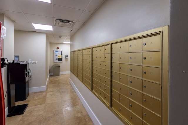 corridor featuring mail boxes and a drop ceiling