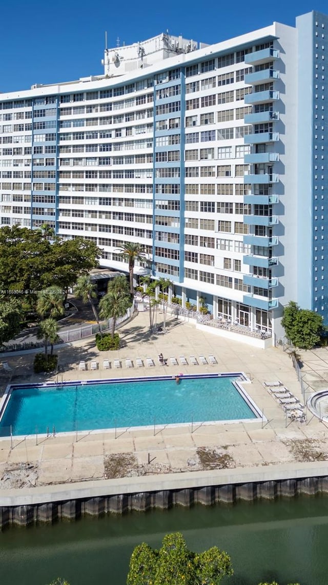 view of pool featuring a patio area and a water view