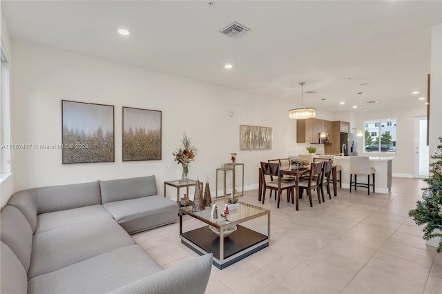 tiled living room featuring an inviting chandelier