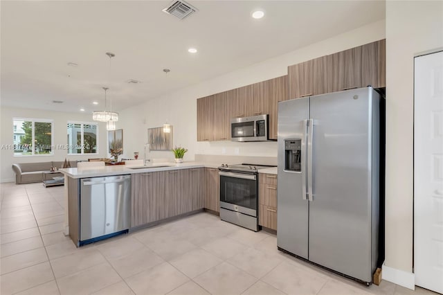 6425 NW 103rd Pl Unit 102, Doral, FL 33178 - kitchen with appliances with stainless steel finishes, light countertops, a peninsula, a sink, and modern cabinets