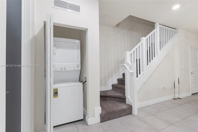 6425 NW 103rd Pl Unit 102, Doral, FL 33178 - clothes washing area featuring stacked washer and clothes dryer, light tile patterned flooring, baseboards, recessed lighting, and light carpet