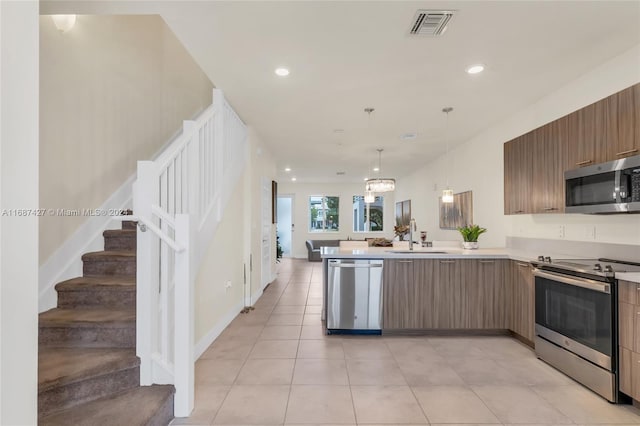 6425 NW 103rd Pl Unit 102, Doral, FL 33178 - kitchen featuring stainless steel appliances, a sink, modern cabinets, a peninsula, and light countertops