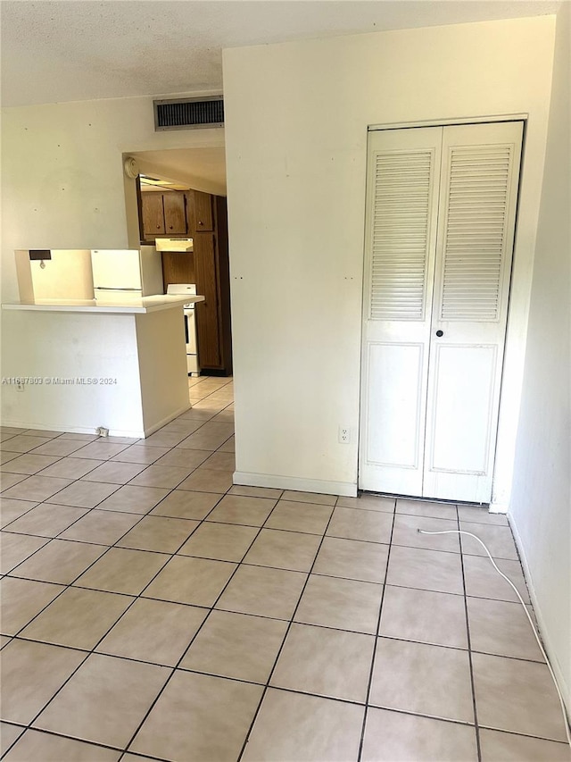 interior space with light tile patterned floors and a textured ceiling